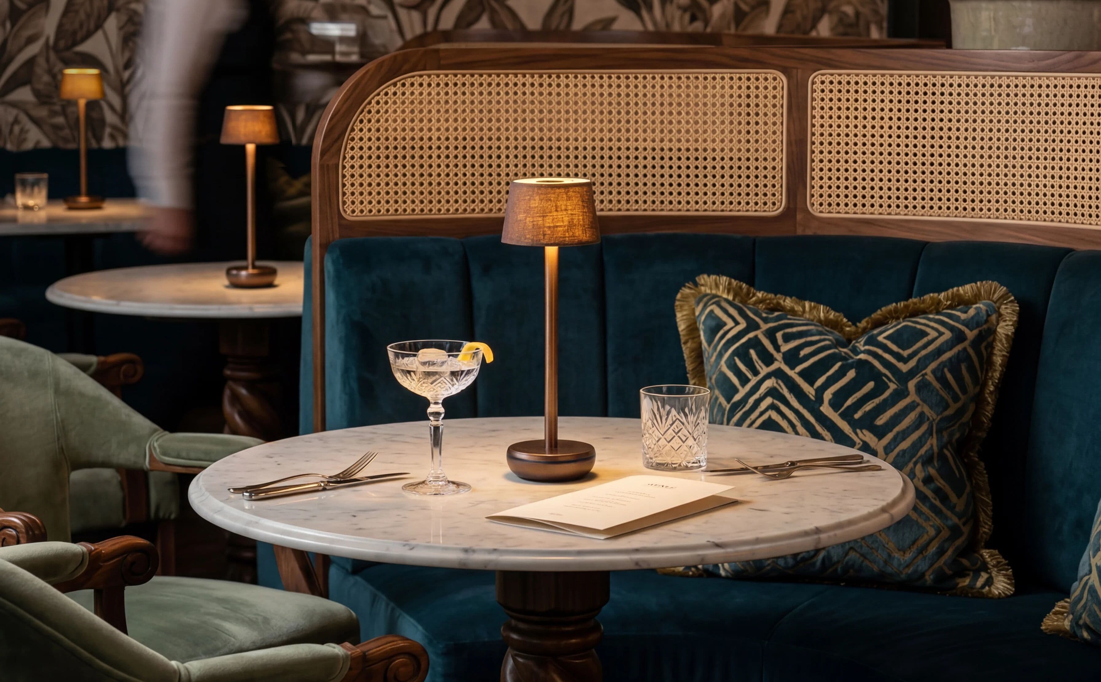 A Humble cordless table light in bronze on a linen-dressed table